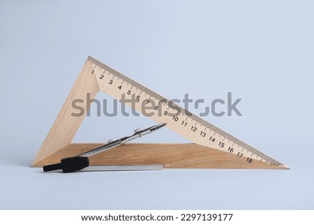 Triangle ruler and compass on white background