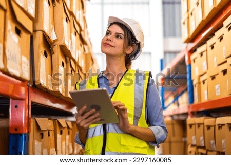 Portrait engineer woman shipping order detail check goods and supplies on shelves with goods background inventory in factory warehouse.logistic industry and business export