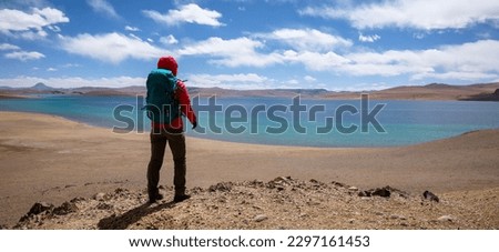 Woman backpacker hiking in beautiful winter high altitude mountains