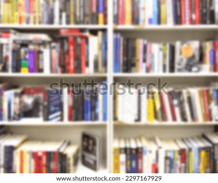 Abstract blurred modern white bookshelves with books. Blur manuals and textbooks on bookshelves in library or in book store. Concept for education. Library interior bokeh background.