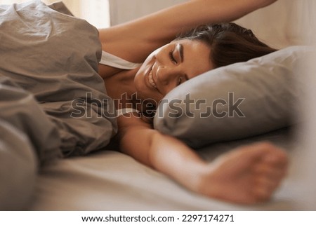 Bed, stretching and happy woman waking up in the morning after sleep, rest and relax in her home. Resting, smile and female stretch in her bedroom, content and peaceful, cheerful and comfortable Royalty-Free Stock Photo #2297174271