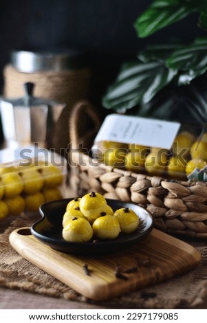 Tart ananas filled with sweet pineapple jam or Kue Kering Nastar on black plate wooden board is usually served on Indonesian Muslim holidays, Eid al-Fitr. Still life dark moody food photography