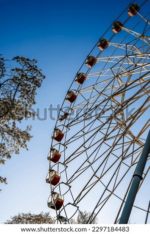 Ferris wheel in the amusement park against the background of the summer sky