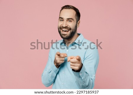 Young smiling confindent caucasian man 20s wear classic blue shirt point index finger camera on you say do it motivating isolated on plain pastel light pink background studio People lifestyle concept