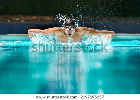 Fitness, sport and training with man in swimming pool for competition, workout and energy. Strong, water splash and cardio with male swimmer and practice for athlete, championship and race at gala Royalty-Free Stock Photo #2297195157