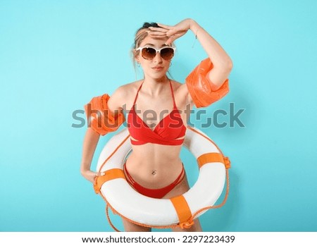 Woman with armrests and lifebuoy ready to rescue at sea Royalty-Free Stock Photo #2297223439
