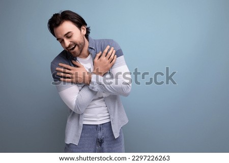 emotional young brutal brunette guy on a studio background for a poster