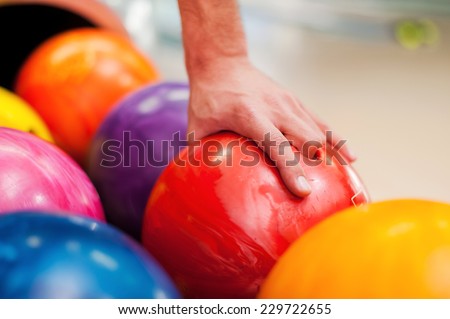 I choose this one. Close-up of a hand holding bowling ball  
