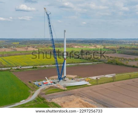 Construction of a wind turbine with a blue crawler crane Royalty-Free Stock Photo #2297256733