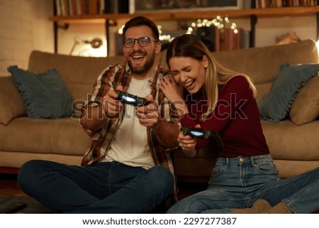 Young couple having fun at home playing video games Royalty-Free Stock Photo #2297277387
