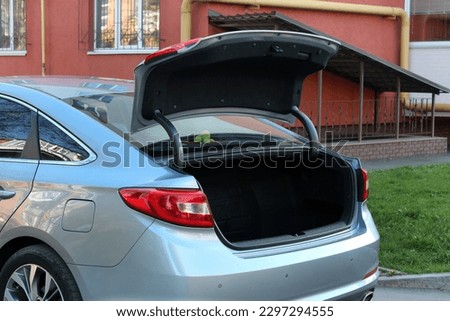 Grey Car with open trunk. Modern car with open empty trunk outdoors. Royalty-Free Stock Photo #2297294555