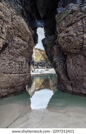 Natural rock arches Cathedrals beach, Playa de las catedrales at Ribadeo, Galicia, Spain. Famous beach in Northern Spain Atlantic. Natural rock arch on Cathedrals beach in low tide. Royalty-Free Stock Photo #2297312411
