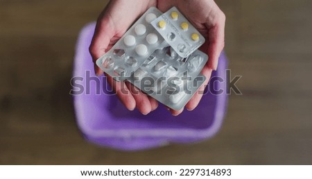 Close up woman hand throws medicine pills into the trash. The concept of the healthcare industry. Royalty-Free Stock Photo #2297314893