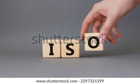 ISO standards quality control symbol. Concept word ISO on wooden cubes. Businessman hand. Beautiful grey background. Business and ISO concept. Copy space.