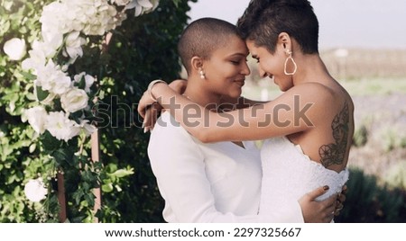 They find happiness in each other. an affectionate young lesbian couple standing with their arms around each other on their wedding day. Royalty-Free Stock Photo #2297325667