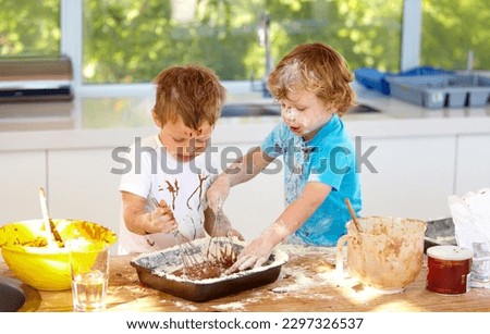 Baking, children and messy friends in the kitchen together, having fun with ingredients while cooking. Kids, food and bake with naughty young brother siblings making a mess on a counter in their home Royalty-Free Stock Photo #2297326537