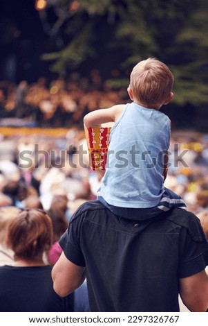 Back, festival and a boy sitting on dad shoulders outdoor at a music concert together for bonding or entertainment. Family, kids and crowd with a father carrying his child son outside at an event