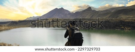 camera in the photographer hand in lake background
