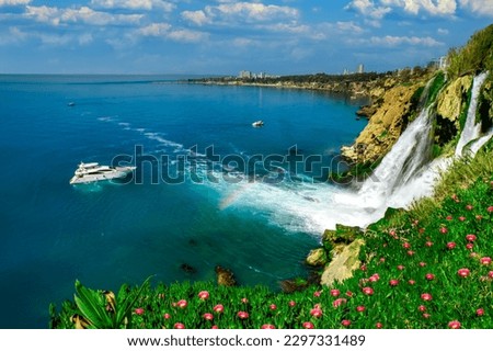 Lower Düden Falls drop off a rocky cliff falling from about 40 m into the Mediterranean Sea in amazing water clouds. Tourism and travel destination photo in Antalya, Turkey.