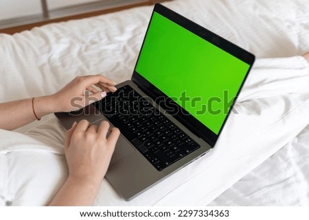Close up smart caucasian teenage girl female hands using laptop green blank screen Chroma Key. Woman typing on the keyboard using touchscreen. Online shopping, browsing internet
