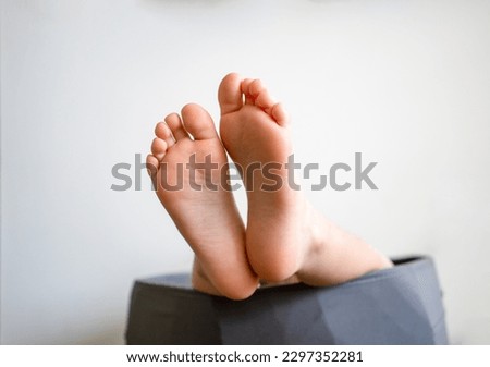 Cozy holidays at home. Close up photo of little child barefooted feet. Leisure time. Sweet childhood. Copy space.