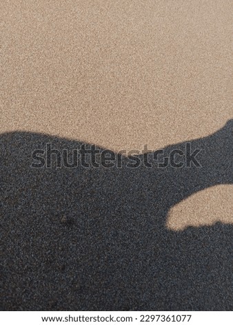 the black shadow on the sea sand is beautiful and nice and pretty