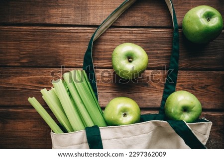 green apples and celery in an eco bag