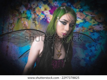 green hair goth fairy with wings and colorful background with focus on her face