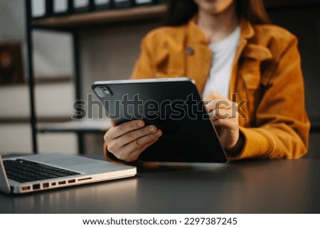 Businesswoman hand using laptop, tablet and smartphone in office. Digital marketing media mobile app and discussing plan new start up project. Finance task.
 Royalty-Free Stock Photo #2297387245
