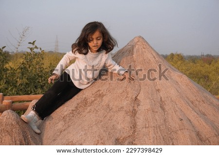 Kid having fun in park with beautiful blur background and different style portrait photo. Selective subject of hill climbing pose. 