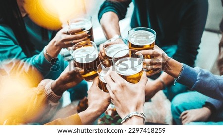 Group of people drinking beer at brewery pub restaurant - Happy friends enjoying happy hour sitting at bar table - Closeup image of brew glasses - Food and beverage lifestyle concept Royalty-Free Stock Photo #2297418259