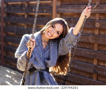 Young fashion girl having fun on swing