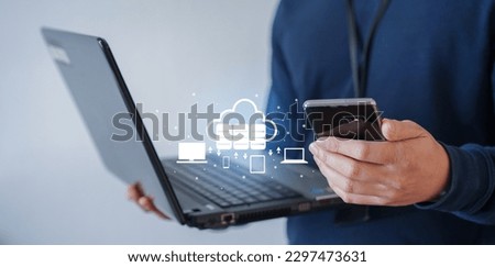close up network engineer man hand hold smartphone to contact team about installation and synchronize data for backup on cloud computing network in operation room with virtual system for techno Royalty-Free Stock Photo #2297473631