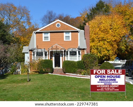 For Sale Real Estate Sign on front yard lawn of suburban house residential neighborhood fall season clear blue sky USA