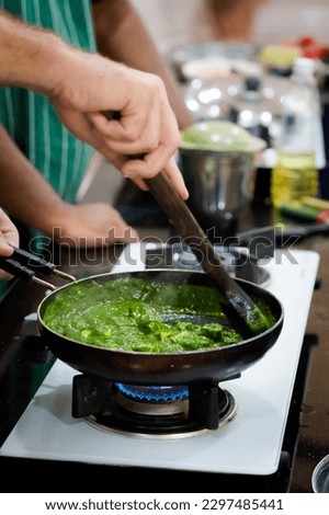 Traditional way of preparing indian food palak paneer (spinach with cheese) using gas pan. Picture of traditional India cuisine made of fresh ingredients taken during cooking class in Goa