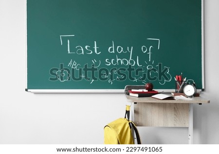 Text LAST DAY OF SCHOOL with drawings on blackboard in classroom Royalty-Free Stock Photo #2297491065
