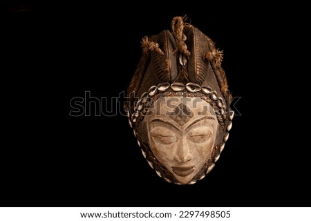 Traditional African tuna (beauty) mask from Gabon against a black background Royalty-Free Stock Photo #2297498505