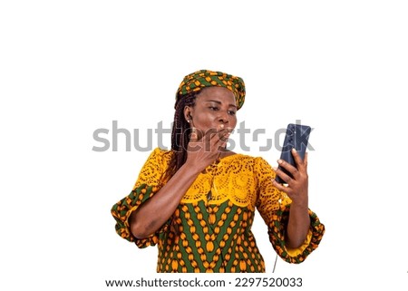 a beautiful mature woman in traditional dress standing on a white background making a kiss outside of a video call.