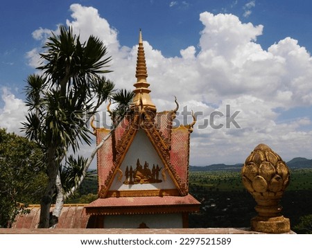 Detail of ornate Buddhist temple with golden decoration at Phnom Sampeau, Battambang, Cambodia with beautiful sky for copy space. High quality photo