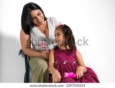 Mother looks at her Latina daughter with tenderness showing affection and love