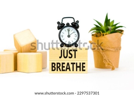 Just breathe and psychological symbol. Concept words Just breathe on wooden block. Beautiful white table white background. Black alarm clock. Business psychological Just breathe concept. Copy space