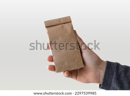 Craft Paper Bag in Hand over white surface