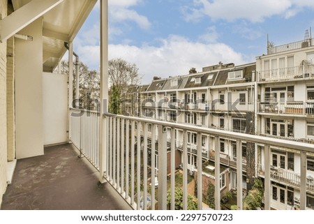 a balcony with some buildings in the background and blue sky above it, as seen from an apartment's balcony