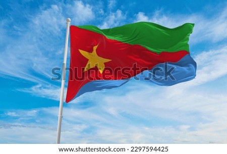 flag of Ethiopian Semitic peoples Tigrinyans at cloudy sky background, panoramic view. flag representing extinct country,ethnic group or culture, regional authorities. copy space. 3d illustration Royalty-Free Stock Photo #2297594425