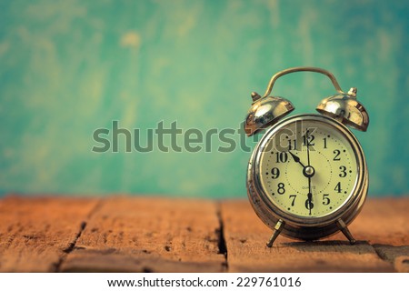 Vintage background with retro alarm clock on table Royalty-Free Stock Photo #229761016