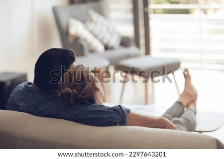 Chilled hubby and wifey vibes. High angle shot of an unrecognizable couple relaxing on their couch at home. Royalty-Free Stock Photo #2297643201