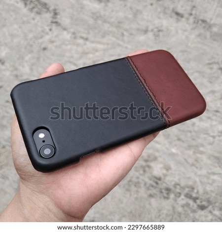 Multicolored leather mobile phone case on a textured background. Isolated copy space objects. 
