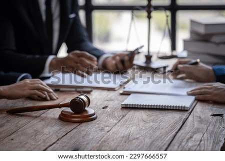 justice and law concept. male lawyer working in an office. Legal law, advice, and justice concept. The client is bringing the documents to clarify the law to the lawyer at the prosecutor's office.
