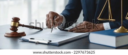 Young lawyer or legal advisor is reading and carefully checking the validity of documents and investment agreements for signing contracts managing justice concepts. Royalty-Free Stock Photo #2297673625