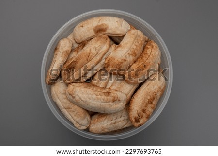 Toasted bananas packed in a transparent box on gray background Grill bananas are popular thailand dessert for healthy people who need to diet.